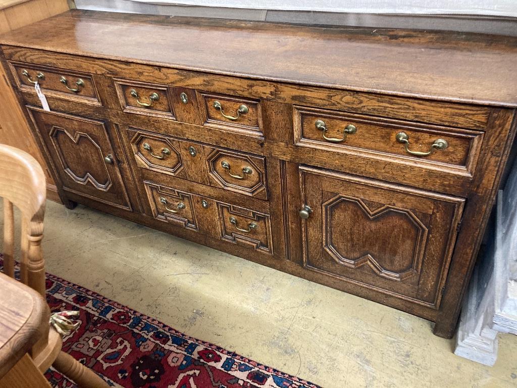 An early 18th century oak low dresser, with a geometric block mounted front, length 184cm, depth 45cm, height 82cm